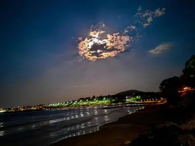 a cloud in the sky over a beach at night at Dima Popova Apartments in Tsarevo