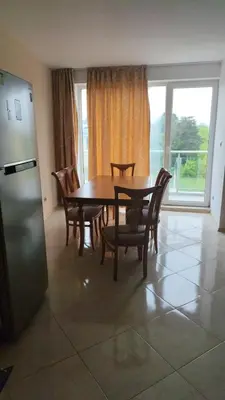a dining room with a table and chairs and a refrigerator at Dima Popova Apartments in Tsarevo