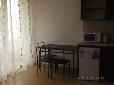 a kitchen with a table and chairs and a microwave at Dima Popova Apartments in Tsarevo