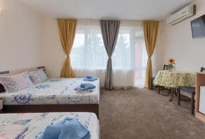 a bedroom with two beds and a window at Kazlarov Guest House in Kiten