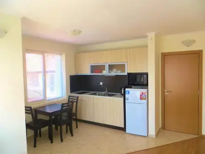 a kitchen with a blue refrigerator and a table and chairs at Apartments in Azalia 2 Complex in Nesebar
