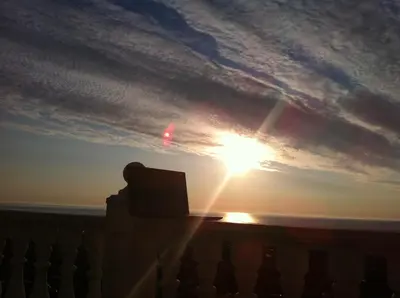 a sunset over the ocean with a laptop on a balcony at Villa Sky Music in Obzor
