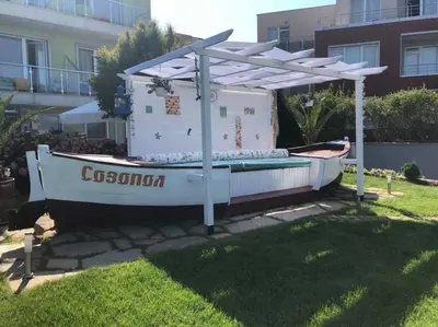 a boat sitting under a pergola in a yard at Villa St Anna in Sozopol