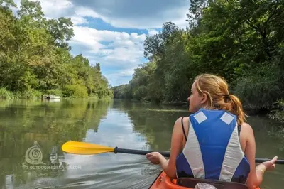 a woman is in a kayak on a river at Бунгала Виктория - Камчия in Kamchia