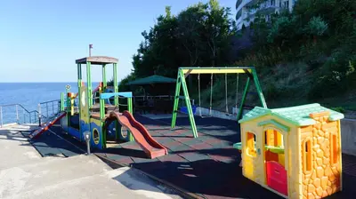 a playground with two swings and a slide at Плажни Апартаменти Силвър Бийч - Silver Beach Sea Apartments in Byala