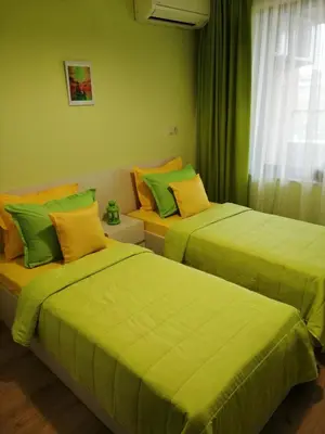 two beds in a room with green and orange at Sunny in Burgas City