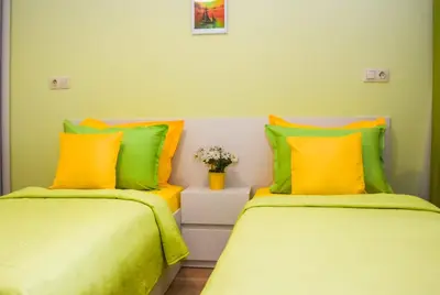 two beds in a room with green and yellow at Sunny in Burgas City