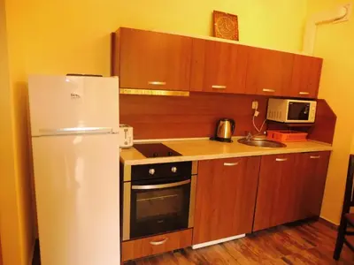 a kitchen with a white refrigerator and wooden cabinets at AMADEUS 5 in Sunny Beach