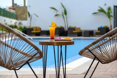 a table with a drink on it next to two chairs at JI HOTEL in Sozopol