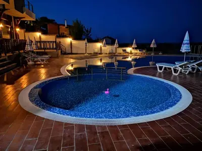 a pool at night with a pink ball in it at St George Apartcomplex in Shkorpilovtsi