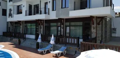 a building with two blue chairs on a deck at St George Apartcomplex in Shkorpilovtsi