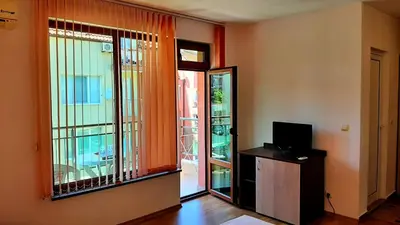 a room with a window and a door with a television at Adri Guest House in Nesebar