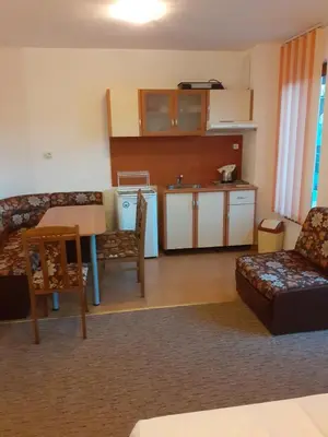 a living room with a couch and a table and a kitchen at Adri Guest House in Nesebar