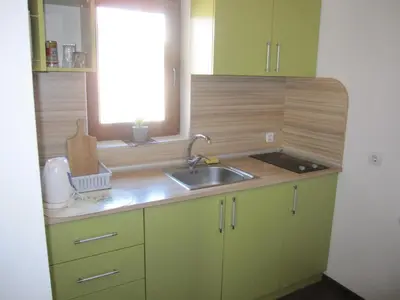 a kitchen with green cabinets and a sink and a window at Neli Sea Villa in Sozopol