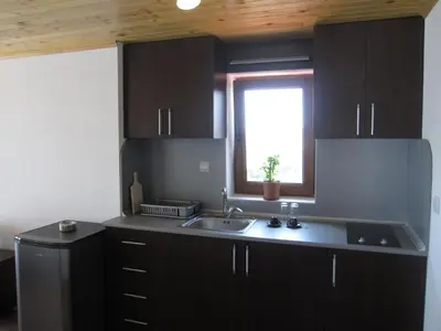 a kitchen with black cabinets and a sink and a window at Neli Sea Villa in Sozopol