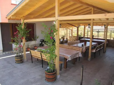 a pavilion with wooden tables and benches and potted plants at Neli Sea Villa in Sozopol