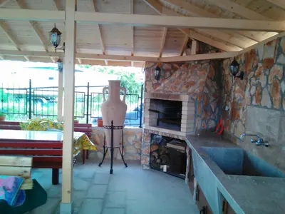 a kitchen with a fireplace and a stone wall at Neli Sea Villa in Sozopol