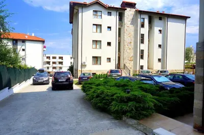 a parking lot with cars parked in front of a building at Комплекс Бяла Виста до Плажа - Complex Byala Vista near the beach in Byala