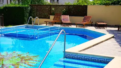 a swimming pool with two chairs and a swimming pool at Комплекс Бяла Виста до Плажа - Complex Byala Vista near the beach in Byala