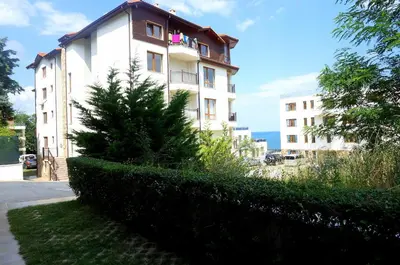 a white building with a tree in front of it at Комплекс Бяла Виста до Плажа - Complex Byala Vista near the beach in Byala