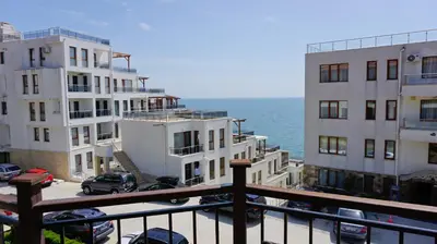 a view of buildings and the ocean from a balcony at Комплекс Бяла Виста до Плажа - Complex Byala Vista near the beach in Byala