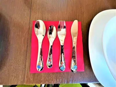 a group of silver utensils sitting on a red napkin at Botabara 312 Beach Front Apartment in Pomorie