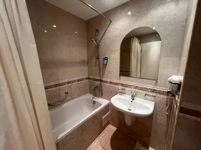 a bathroom with a sink and a bath tub and a mirror at Miramar Front Beach Self Catering Apartments No Swim Pool Access in Sunny Beach