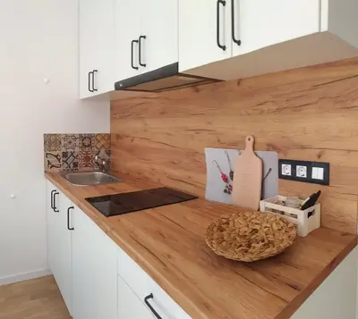 a kitchen with white cabinets and a wooden counter top at Loli’s Beach Studio in Burgas City