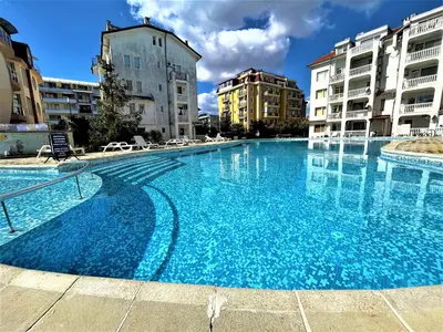 a large blue swimming pool with buildings in the background at Bravo 5 Apartments in Sunny Beach