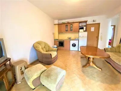 a living room with a table and chairs and a kitchen at Bravo 5 Apartments in Sunny Beach