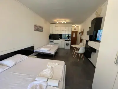 a small room with a bed and a kitchen at MM Complex Dimitrovi in Primorsko