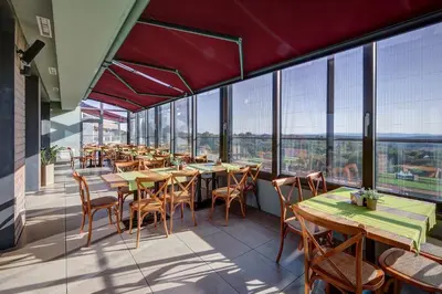 a restaurant with tables and chairs and large windows at Eco complex Zdravets near Varna in Zdravets
