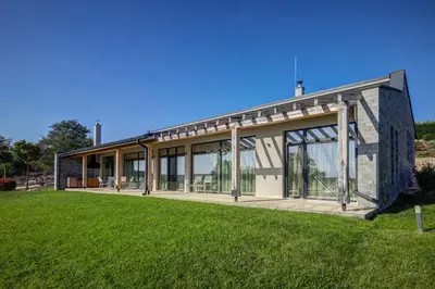 a building with glass doors on a grass field at Eco complex Zdravets near Varna in Zdravets