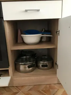 a kitchen cabinet with some pots and pans in it at Familienapartment am Strand in Primorsko in Primorsko