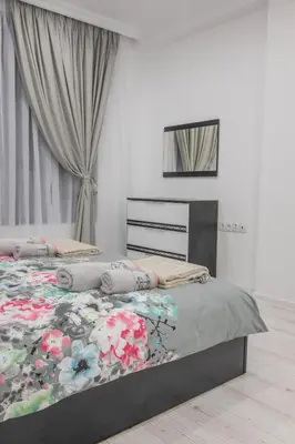 a bedroom with a bed with a floral comforter at Vip Luxury APARTMENT in Burgas City