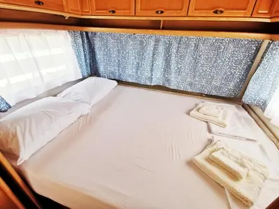a bed with two towels sitting on top of it at бунгала и kаравани Дрийм къмпинг Гардения in Kiten
