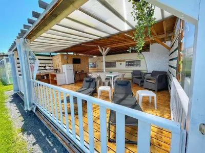 a patio with a table and chairs on a deck at бунгала и kаравани Дрийм къмпинг Гардения in Kiten