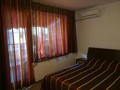 a bedroom with a bed and a window with curtains at 2-х комнатные апартаменты в г.Поморие Болгария in Pomorie