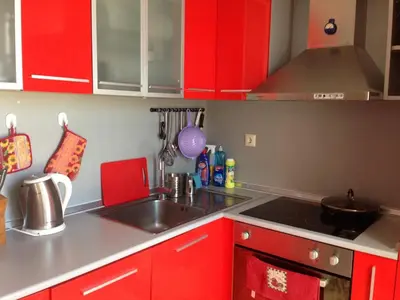 a kitchen with red cabinets and a sink at 2-х комнатные апартаменты в г.Поморие Болгария in Pomorie