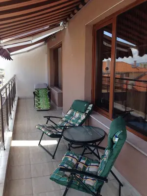 a patio with two chairs and a table on a balcony at 2-х комнатные апартаменты в г.Поморие Болгария in Pomorie