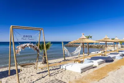 a row of beach chairs and umbrellas on a beach at Onyx Beach Residence - Free Beach Access & Parking in Sveti Vlas