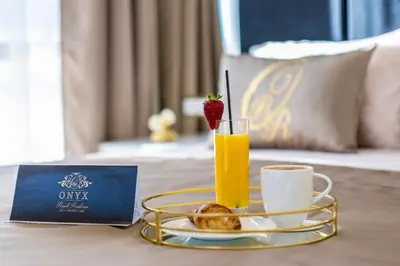 a tray with a cup of orange juice and a strawberry on a table at Onyx Beach Residence - Free Beach Access & Parking in Sveti Vlas