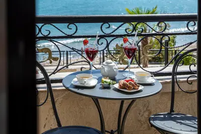a table with wine glasses and food on a balcony at Onyx Beach Residence - Free Beach Access & Parking in Sveti Vlas