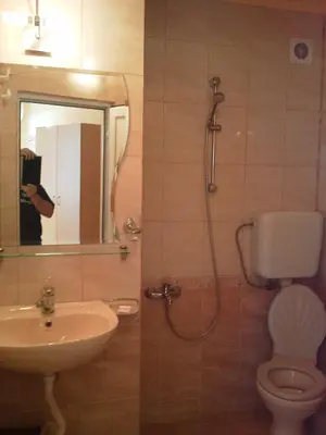a bathroom with a sink and a toilet and a mirror at Krasi Hotel in Ravda