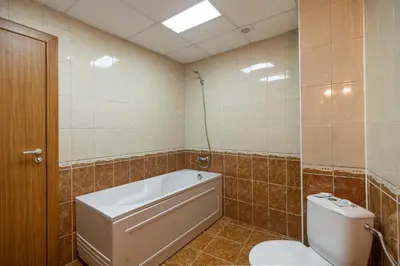 a bathroom with a bath tub and a toilet at Adamo Hotel in Varna City