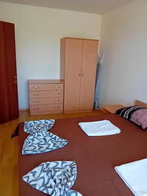 a bedroom with two beds and a dresser in it at Panorama Vigo Nesebar in Nesebar