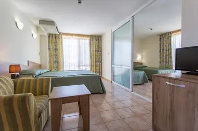 a hotel room with two beds and a flat screen tv at Hotel Longosa - All Inclusive in Sunny Beach