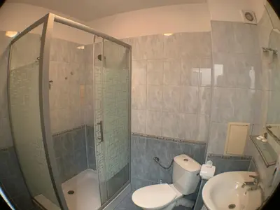 a bathroom with a shower and a toilet and a sink at Samuil Apartments - Central Burgas in Burgas City