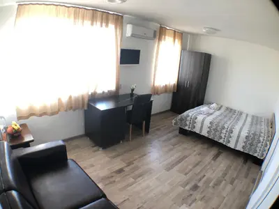 a living room with a desk and a bed at Samuil Apartments - Central Burgas in Burgas City