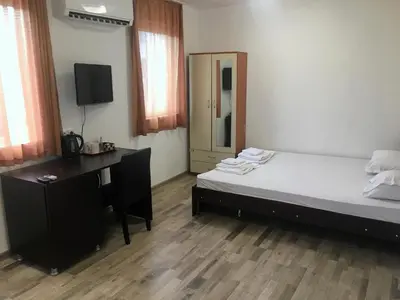 a bedroom with a bed and a desk with a computer at Samuil Apartments - Central Burgas in Burgas City